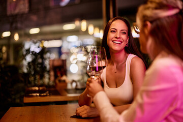 Smiling Friends Enjoying Wine at a Cozy Evening Restaurant
