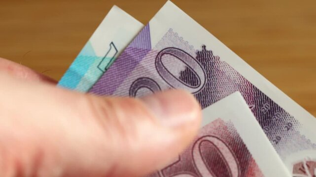 UK money. british pounds slowly counted in fingers. GBP Currency, Financial concept, close-up