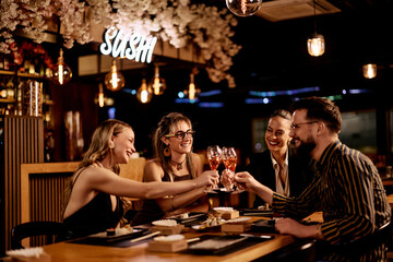 Friends Enjoying Sushi Dinner at Trendy Restaurant with Cheers