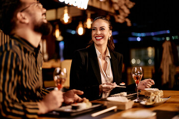 Smiling Friends Enjoying Dinner and Drinks at a Modern Restaurant