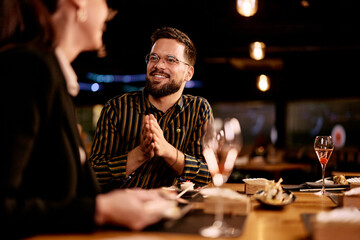 Smiling Man Enjoying a Lively Evening at a Cozy Restaurant