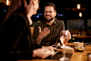 Smiling Man Enjoying Dinner Conversation In Cozy Restaurant