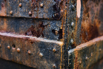 A detailed close up image of a rusty metal object featuring a hole in it