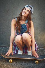 Woman, skateboard and portrait with smile, confidence and sports hobby on city gray wall. Gen z, cool and trendy girl with attitude, skater and edgy with positivity for creativity and holiday town © CamPen2000/peopleimages.com