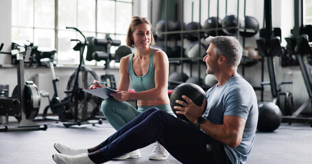 Personal Trainer Showing Abdominal Sit Up Workout In Gym