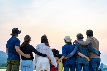 back view group of family and friends standing by the river,looking forward to the beautiful sunset on mountain