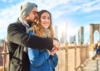 Couple, hug and portrait in city on vacation, honeymoon adventure and breathe in wife for peace. People, bridge and travel to New York on weekend for love, together and embrace for security on date