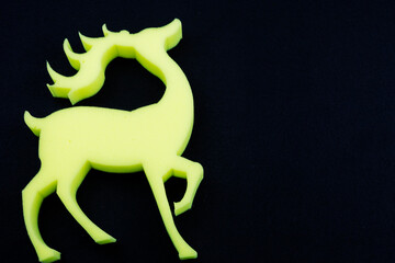 A striking yellow deer with impressive antlers on a black background