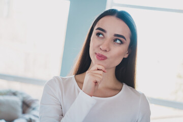 Photo of pretty young woman arm touch chin think wear white pullover bright interior apartment...