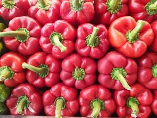 Red peppers all with a green stem. Seen up close.