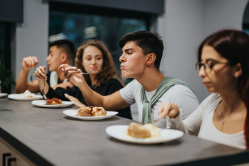 A group of high school students enjoy a meal together, showcasing camaraderie and casual dining in an indoor setting. The atmosphere is relaxed, highlighting friendship and good company.