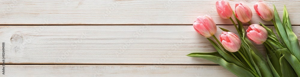 Poster A bouquet of pink tulips on a wooden surface, creating a serene and inviting atmosphere.