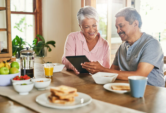 Breakfast, happy and senior couple with tablet for reading morning news, internet puzzle and story. Man, woman and technology in retirement home for article, online information and relax with food