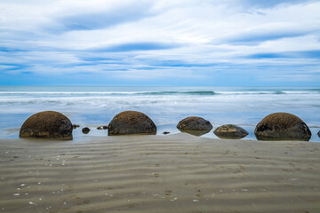 Moeraki Boulders in New Zealand. Famous landmark large spherical stones on Koekohe Beach near Moeraki on New Zealand's Otago coast. A popular tourist attraction