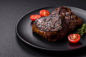Juicy beef steak baked on the grill with salt, spices and herbs