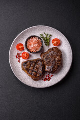 Juicy beef steak baked on the grill with salt, spices and herbs