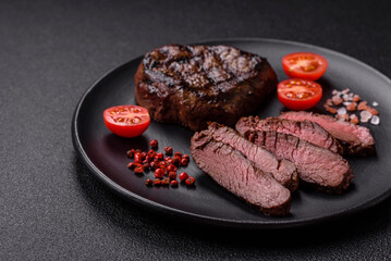 Juicy beef steak baked on the grill with salt, spices and herbs