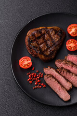 Juicy beef steak baked on the grill with salt, spices and herbs