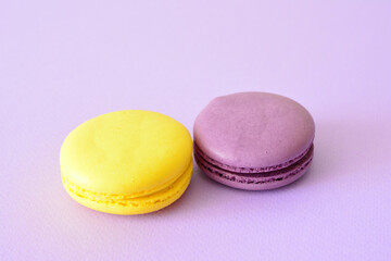 two purple and yellow macarons next to each other on purple background