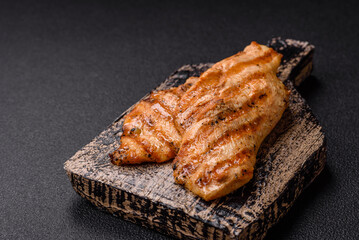 Juicy chicken fillet baked on the grill with salt, spices and herbs