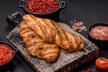 Juicy chicken fillet baked on the grill with salt, spices and herbs