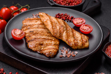 Juicy chicken fillet baked on the grill with salt, spices and herbs