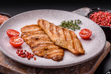 Juicy chicken fillet baked on the grill with salt, spices and herbs