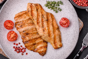 Juicy chicken fillet baked on the grill with salt, spices and herbs