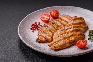 Juicy chicken fillet baked on the grill with salt, spices and herbs