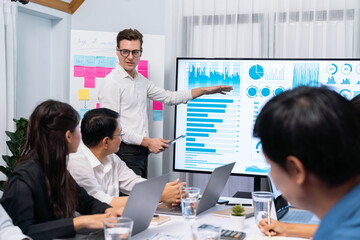 Presentation in office or meeting room with analyst team utilizing BI Fintech to analyze financial data. Businesspeople analyzing BI dashboard power display on TV screen for strategic planning.Prudent