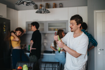 A group of young adults cooking together in a contemporary kitchen, showcasing teamwork, fun, and friendship. Fresh fruits and vegetables are visible on the table.