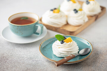 Delicious mini Pavlova meringue cake with whipped cream and fresh fruits.