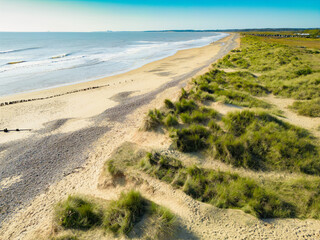 A near empty summer beach on the Suffolk coast in East Anglia. The beach extends for many miles to the new Sizewell C Nuclear construction site.