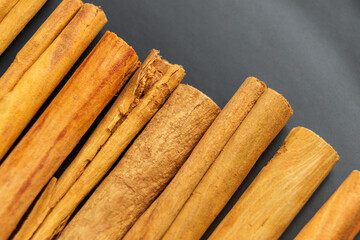 Aromatic whole dried cinnamon sticks on a black plate. Macro shot. Top view