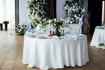 Luxurious restaurant. Luxurious interior, white tables, serving dishes and glasses for guests