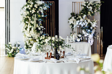 Luxurious restaurant. Luxurious interior, white tables, serving dishes and glasses for guests
