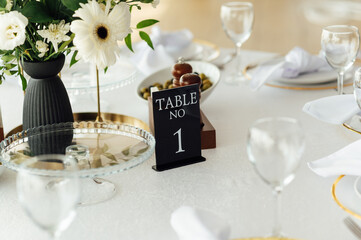 Luxurious restaurant. Luxurious interior, white tables, serving dishes and glasses for guests