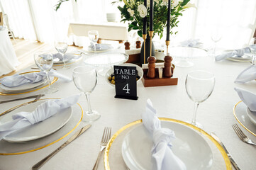 Luxurious restaurant. Luxurious interior, white tables, serving dishes and glasses for guests