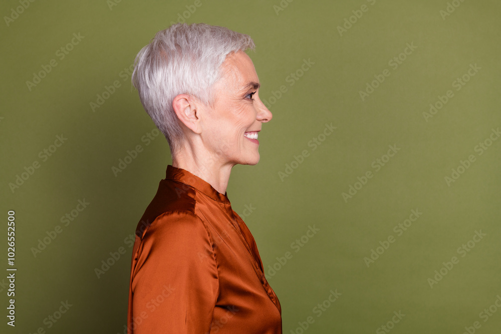 Sticker Photo of lovely pensioner lady profile toothy smile empty space dressed stylish brown formalwear isolated on khaki color background