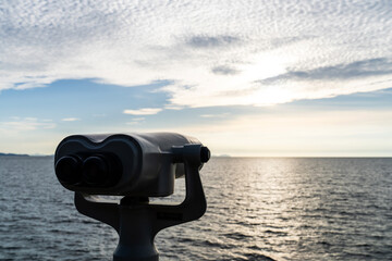 telescope at the seaside during sunset