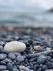 white round stone on the seashore with black sand