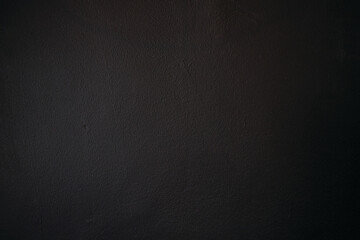 Black rough concrete wall with fine texture - dark grunge background
