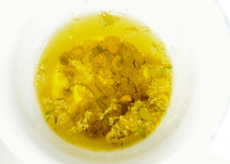 chamomille  tea  on white cup with herbs