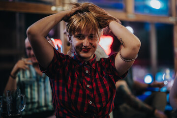 A cheerful woman in a plaid shirt having a great time at a bar with friends, emphasizing happiness and leisure.