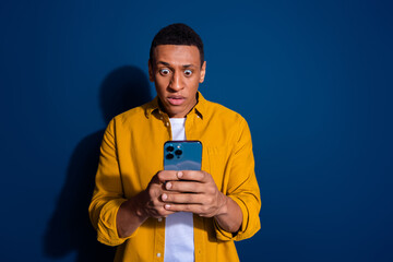 Photo of young funny guy wear yellow shirt using mobile phone staring his account hacked and lost...