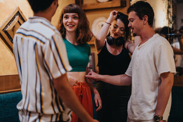 A group of young friends enjoying a casual and fun indoor gathering, laughing and interacting warmly in a cozy setting. The atmosphere is lively and engaging.