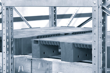 Empty red plastic pallets on racks in an automated warehouse complex