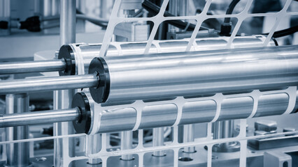 machine packs food products into white plastic containers. The machine has two rollers and a...
