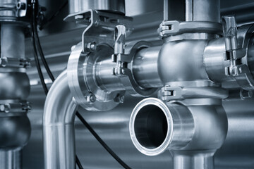 Machine for the production of dairy products with a series of metal stainless steel cylinders and pipes with silver trim. cylinders are connected to each other and appear to be part of a larger system
