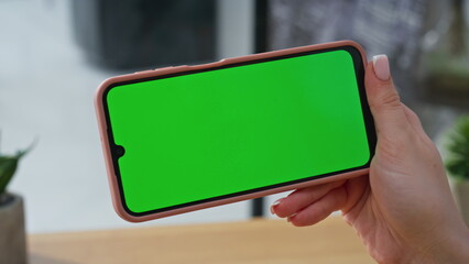 Businesswoman fingers using chromakey smartphone surfing on workplace closeup